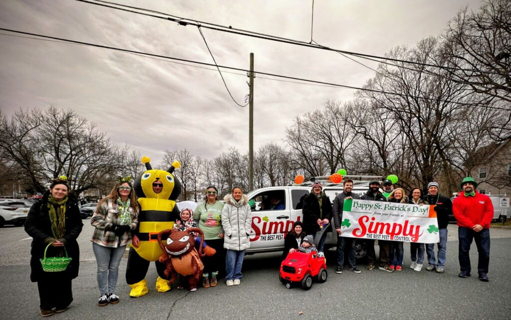 Simply The Best Pest Control team posing in front of service vehicle at the 2026 FSSP St. Patrick's Day Parade in Clinton, NJ
